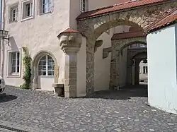 Der wahrscheinlich aus dem 16. Jh. stammende Pranger wurde nach dem Zweiten Weltkrieg rekonstruiert und ist in seiner Form ungewöhnlich. Die beiden Kragsteine im Durchgang dienten als Galgen.