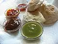 Vier ver­schieden­farbige Saucen, mit Samosas