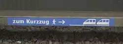 Dieser an einer Stromschiene der U-Bahn München angebrachte Aufkleber weist die Fahrgäste auf die Halteposition eines sogenannten Kurzzugs hin, der nur zwei Drittel der Bahnsteiglänge ausfüllt