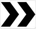 Zeichen R6-4 Kreisverkehrs­richtung (Platziert im inneren Bereich des Kreisverkehrs)