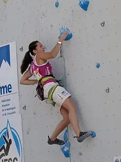 Magdalena Röck klettert in einer Vorstiegsroute mit blauen Griffen