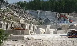 Foto eines Steinbruchs, in dem unter anderem ein Bagger steht