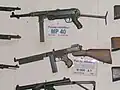Maschinenpistolen (v.&nbsp;o.) MP40, Thompson M1928A1 und (anachronistisch) Sterling-Maschinenpistole