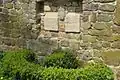 Gedenktafeln in der Kirchhofmauer, die an den ehemaligen Friedhof erinnern, der hier von 1300 bis 1865 lag.