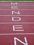 „Menden“-Schriftzug auf der Laufbahn des Huckenohlstadions