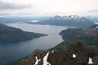 Der Mjøsund (vorn) von Norden, mit der Mjøsundbrua; der Salangenfjord liegt hinter der Brücke