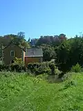 Mühle, im Hintergrund das Schloss Courcillon