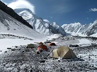 Der Noshak (links mit Wolkenhaube) mit seinem Westgrat vom Basislager (Noshak-Tal in Afghanistan) aus Westnordwest