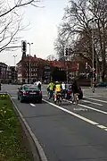 Radfahrer stehen neben Autos