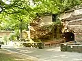 Der Eingang des Raubtierhauses, der einen Tunnel durch den Sandstein bildet; links im Hintergrund die Löwenfreianlage, 2010