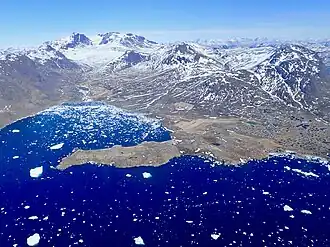 Blick von Narsaq (rechts am Bildrand) nach Nordosten zum Kuannersuit und Ilimmaasap Allequtaa (Steenstrup Fjeld), rechts dahinter der dunkle Ilimmaasaq sowie der Nasaasaaq (Nakkaalaaq)