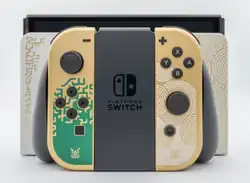Das Foto zeigt im Vordergrund die Joy-Cons im Tears of the Kingdom-Stil mit Halterung und dahinter die Konsole, gedockt in der Docking-Station