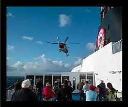 Ein Patient wird bei den Shetland-Inseln ausgeflogen. Der Hubschrauber konnte wegen hohem Wellengang nicht landen und der Patient wurde mit der Winde an Bord geholt.