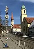 Ortsmitte mit Narren­baum der Oberkochener Narrenzunft „Schlagga-Wäscher“, Stadtbi­blio­thek und St. Peter und Paul