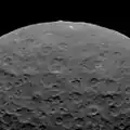 Ansicht von Ceres von Dawn. Die Nord­seite von Ahuna Mons ragt über den Horizont hinaus. Norden befindet sich unten
