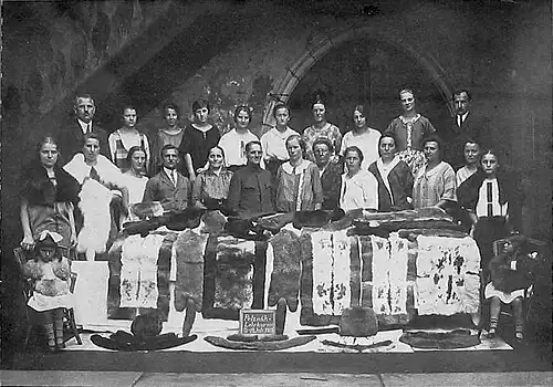 Kaninchenzüchterinnen und Lehrer bei einem Pelzverarbeitungslehrgang mit ihren Kaninfellteppichen (1925)