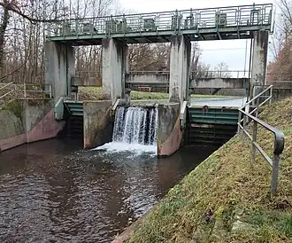 Rossweidschleuse im Pfinz-Entlastungskanal, hinter der Wegschranke die Dammscharte zum Retentionsraum