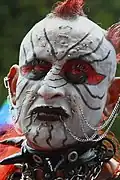 Lippenstift als Teil eines umfangreichen Clown-Make-Ups mit zusätzlichen Piercings