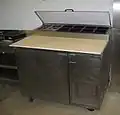 Handelsüblicher Pizzatisch für gastronomische Pizza-Zubereitung, mit gekühltem Aufsatz für Zutaten.