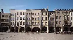 Die markanten Travées an den Fensteröffnungen der Gebäudefassaden stammen aus dem 17. Jahrhundert. Die Dächer sind in „Diamantspitzen“-Form gestaltet. Man erkennt die Gestalt eines Turms, der an der Rückseite der dritten Fassade sichtbar ist und Spuren der alten römischen und mittelalterlichen Mauer trägt.