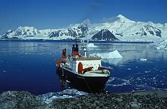 Blick vom Ankerplatz an der Rothera-Station mit dem deutschen Forschungsschiff Polarstern nach Süden über die Ryder Bay auf die Princess Royal Range mit Mount Gaudry als höchster Erhebung