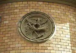 Reliefmedaillon mit Symbolik des Postwesens an der Fassade.