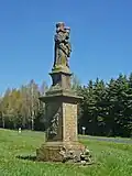 Barockstatue der hl. Maria (Schöne Maria) von 1753 (lt. Inschrift) am heutigen Standort an der Straßenkreuzung Silnic II/223-II/224 an der Talsperre Preßnitz. Ehemaliger Standort war westlich vom Friedhof der Nikolaikirche am Dörnsdorfer Weg