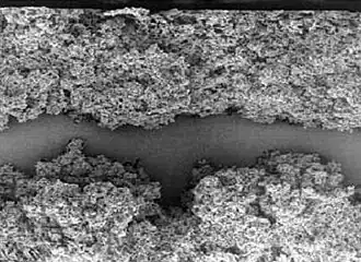 Elektro­chemisch geätzte (auf­geraute) Oberfläche einer 10&nbsp;V-Niedervolt-Anodenfolie eines Aluminium-Elektrolytkondensator