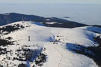 Luftaufnahme mit Seebuck (vorn), Feldberggipfel (links) und Baldenweger Buck (rechts); weit im Hintergrund, jenseits des Hochnebels im Oberrheingraben die Vogesen