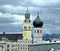 links: Pfarrkirche St. Nikolaus, rechts: Heilig-Geist-Kirche, im Hintergrund die Kampenwand