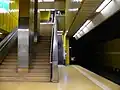 Treppe und dahinter die Rolltreppe auf der Bahnsteigebene