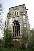 Ein dreistufiger Turm; im unteren Abschnitt ist eine Tür, darüber in der Mitte ein großes Fenster und im oberen Abschnitt befindet sich die Öffnung für die Glocken.