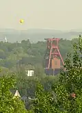 SchachtZeichen neben Schacht XII des Weltkulturerbes Zeche Zollverein, Essen (von der etwa 3,5 km nördlich liegenden Schurenbachhalde aus aufgenommen)