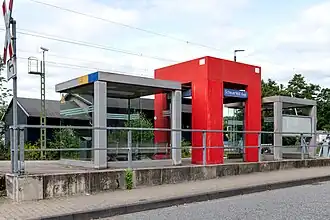 Der DB PlusPunkt am Bahnsteig Richtung Siegen, dahinter (am Gegengleis) ein ehemaliger Güterschuppen