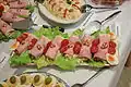 Schinkenrollen aus Pressschinken auf grünem Salat