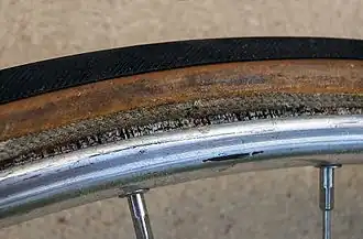 Schlauchreifen auf Felge (wenig Luft und Reifen angehoben zur Veranschaulichung des Klebers)