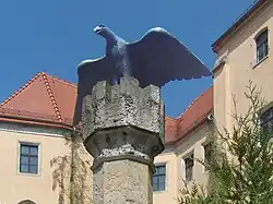 Adlersäule am Eingang.