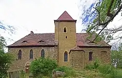 Ansicht von Süden mit romanischem Portal und barocken Sarkophagen