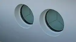 Innen heruntergeklappte Seeschlagblenden zur Sicherung der Bullaugen der Spiekeroog&nbsp;I (Sicht von außen)