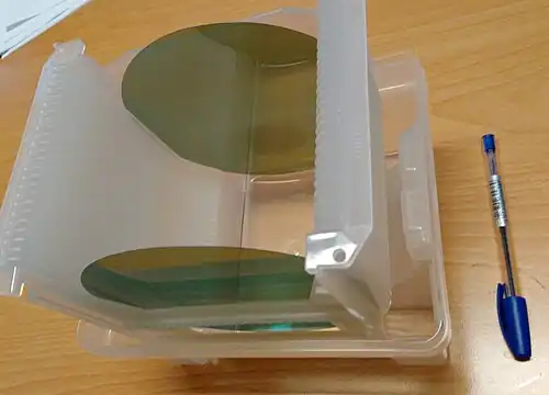 Zwei ∅150-mm-Siliciumcarbid-Wafer, im sichtbaren Bereich des Lichts teilweise transparent