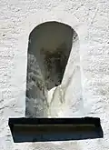 Ehemaliges Fenster, außen an der Unterseite des Turms