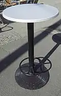 Stehtisch mit einem metallenen Stand­rohr mit schwerer Fuß­platte und Fußstützen-Ring