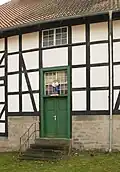 Glasbläserfigur über der Tür des Glashüttengebäudes