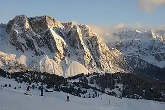 Die nordwestlichen Steviawände und rechts im Hintergrund die Sellagruppe von der Aschgleralm aus betrachtet. Die Pela de Vit teilt sich von links nach rechts im O.-, Mittel- und SW.-Gipfel[1]