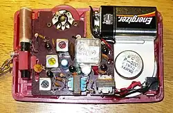 Geöffnetes AM-Mittelwellen-Transistorradio aus dem Jahre 1960 mit zwei Kreisen, erkenntlich an dem mittig montierten doppelten Drehkondensator, der mittels einer Drehscheibe auf der Frontseite des Radios zur Sendereinstellung bedienbar war.