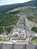 Errichtung der Staumauer. Man erkennt die Seile der Seilbahn zum Betontransport.