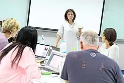 Eine Lehrerin steht vor einer Klasse
