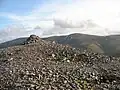 Der Gipfelcairn des Càrn a’ Chlamain, im Hintergrund der Beinn a’ Ghlò
