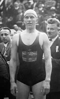 Schwarzweißfoto mit Toivo Reingoldt im dunklen Badeanzug und mit heller Schwimmkappe. Auf der Brust ist die finnische Flagge zu erkennen.