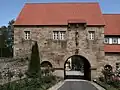 Torhaus, frühes 13. Jh., gotische Marienfigur um 1380; von Abt Schlimbach 1788 renoviert